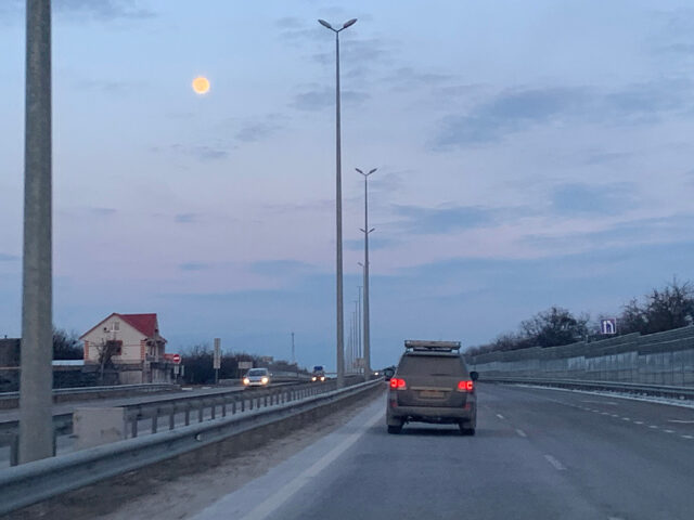 Bil som kjører på veien i skumringen.