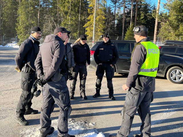 Instruktør i gul vest snakker til fem kolleger som står i halvsirkel.