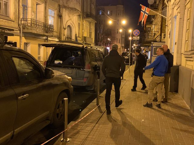 Fire menn i en gate i Ukraina. Det er mørkt.