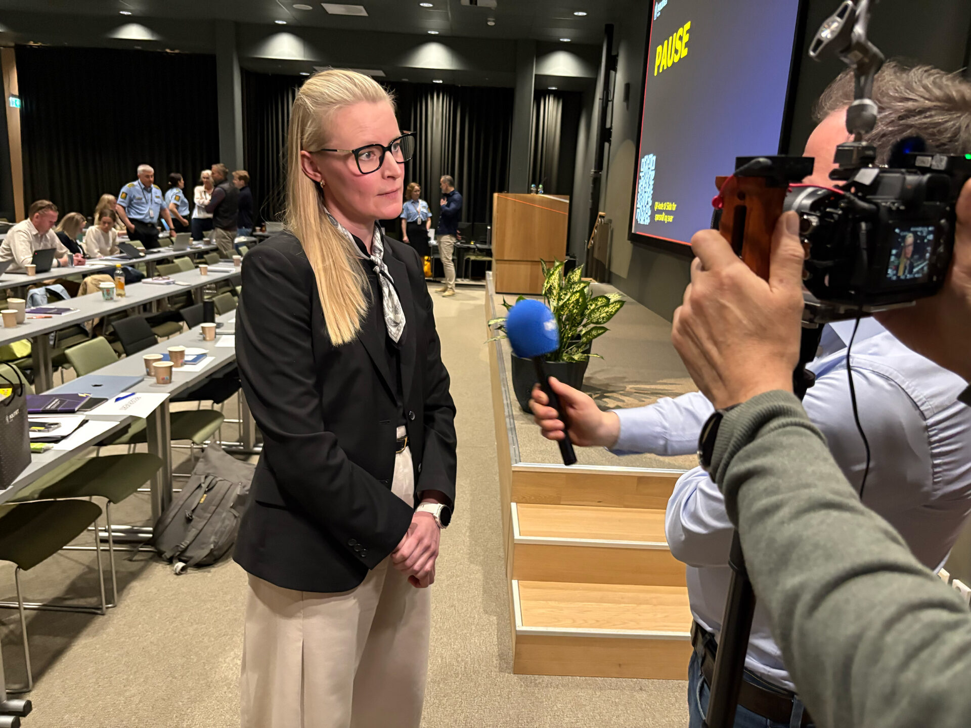 PST-ansatt intervjues av NRK. Står foran et kamera. Foto.