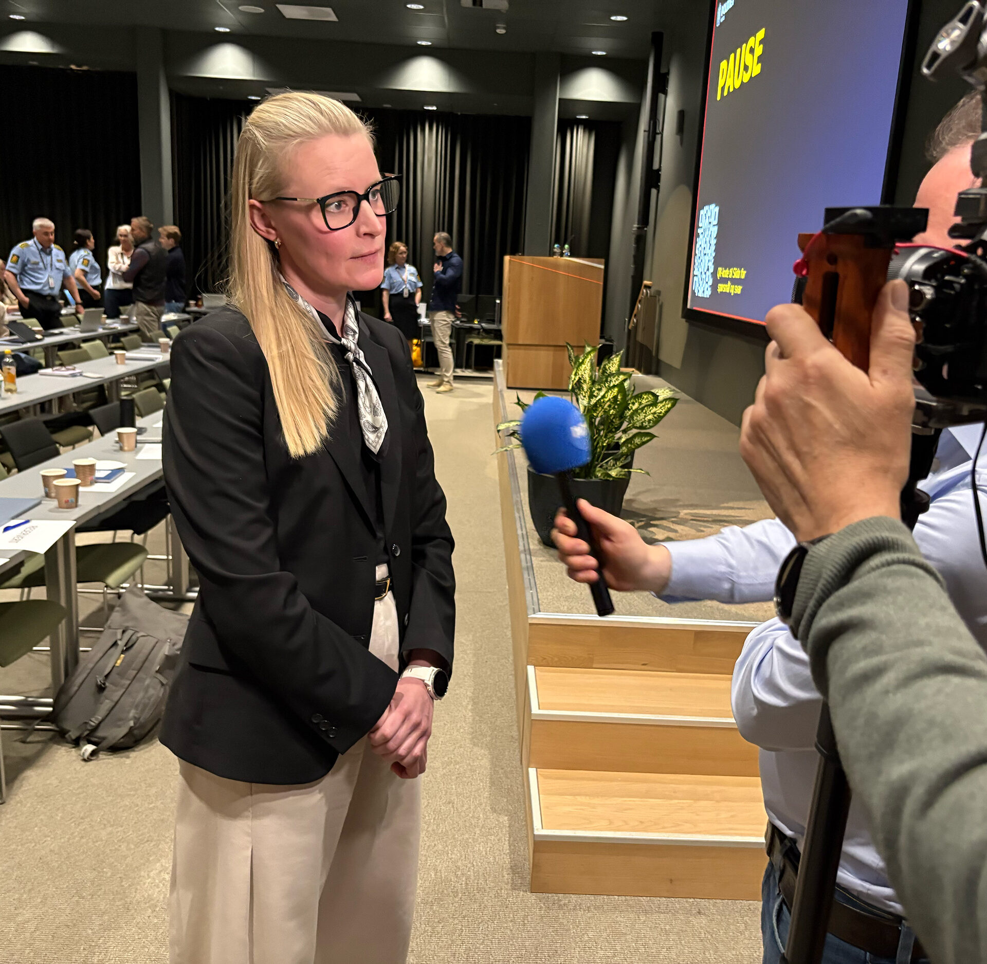 PST-ansatt intervjues av NRK. Står foran et kamera. Foto.