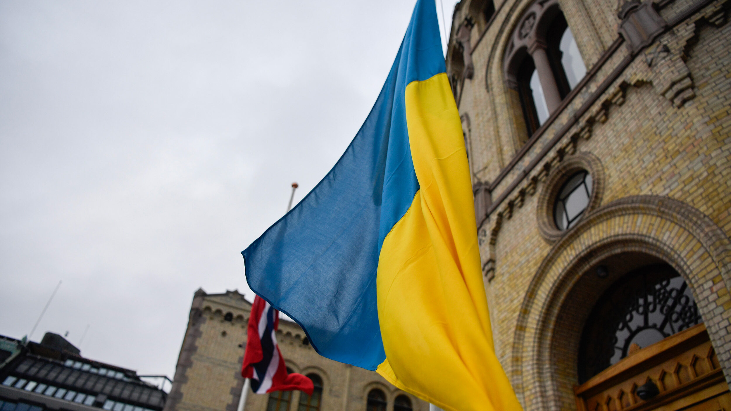 Det ukrainske flagget heises på flaggstang. Stortinget i bakgrunnen. Foto