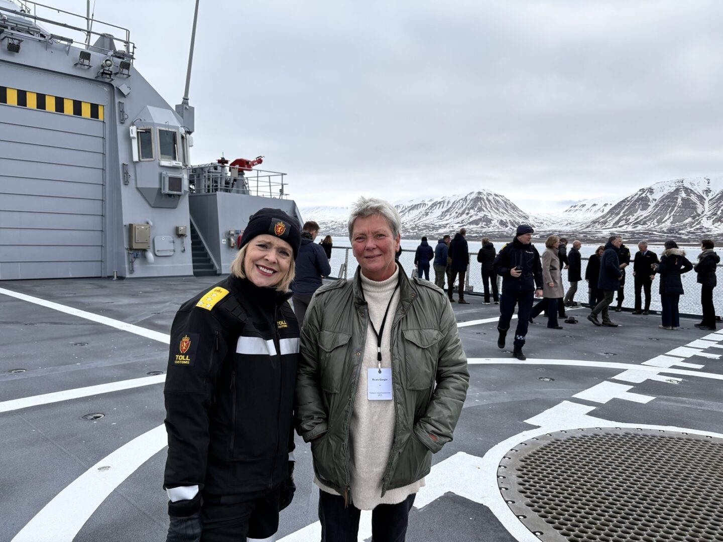 Tolldirektør Benedicte Bjørnland og PST-sjef Beate Gangås på Svalbard med snødekte fjell i bakgrunnen.